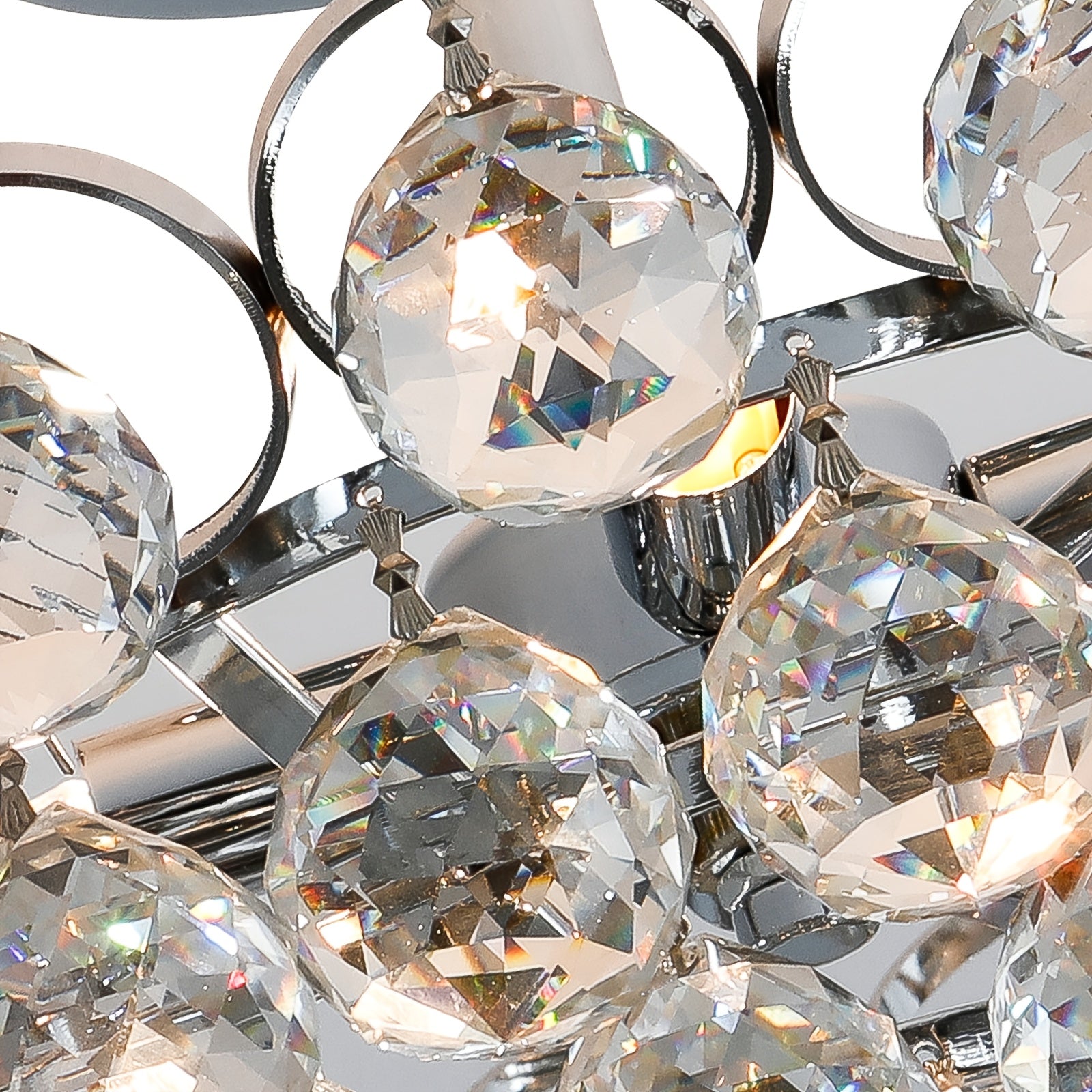 Close-up of crystal bubble light fixture featuring faceted glass spheres and chrome hardware with warm interior glow