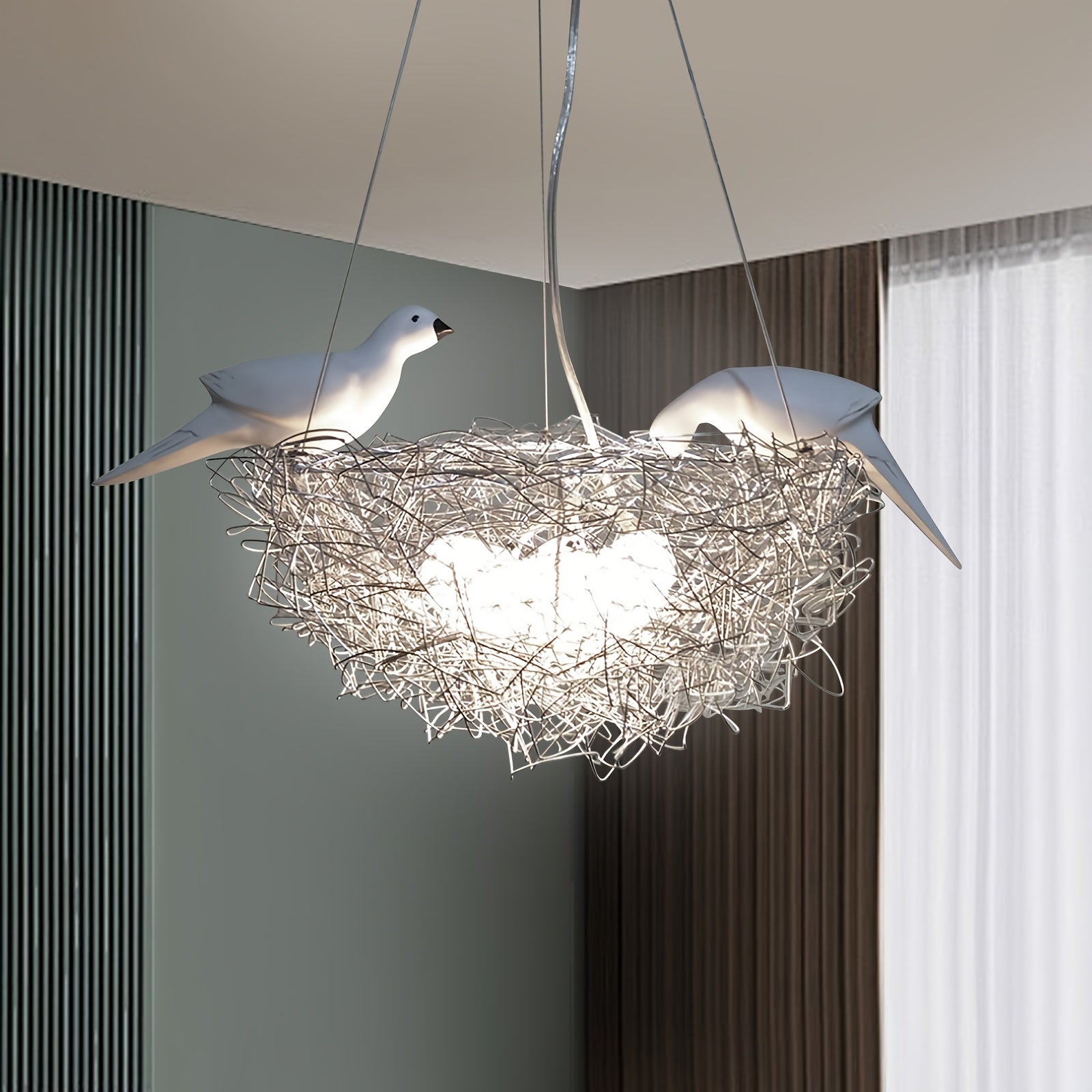 Art-inspired pendant light shaped like a bird nest with two perched birds and woven wire design, creating a soft ambient glow
