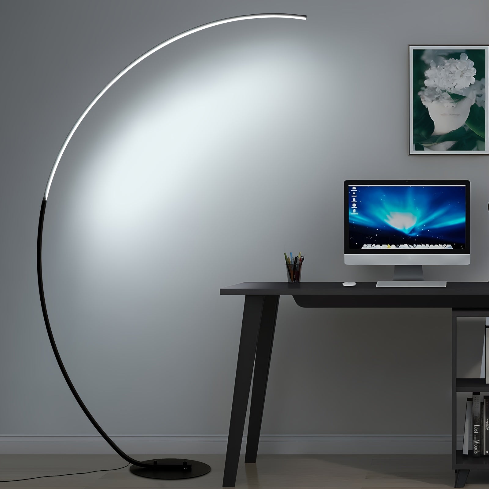 Arc floor lamp casting bright, cool light over a minimalist desk and computer, perfect for enhancing productivity in a home office