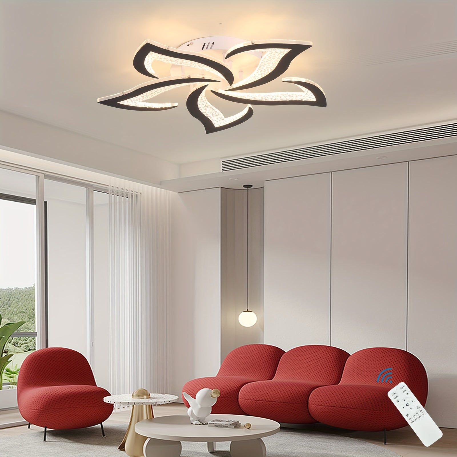 Flower-shaped LED ceiling fixture in black and white, softly illuminating a modern seating area accented by bold red furniture