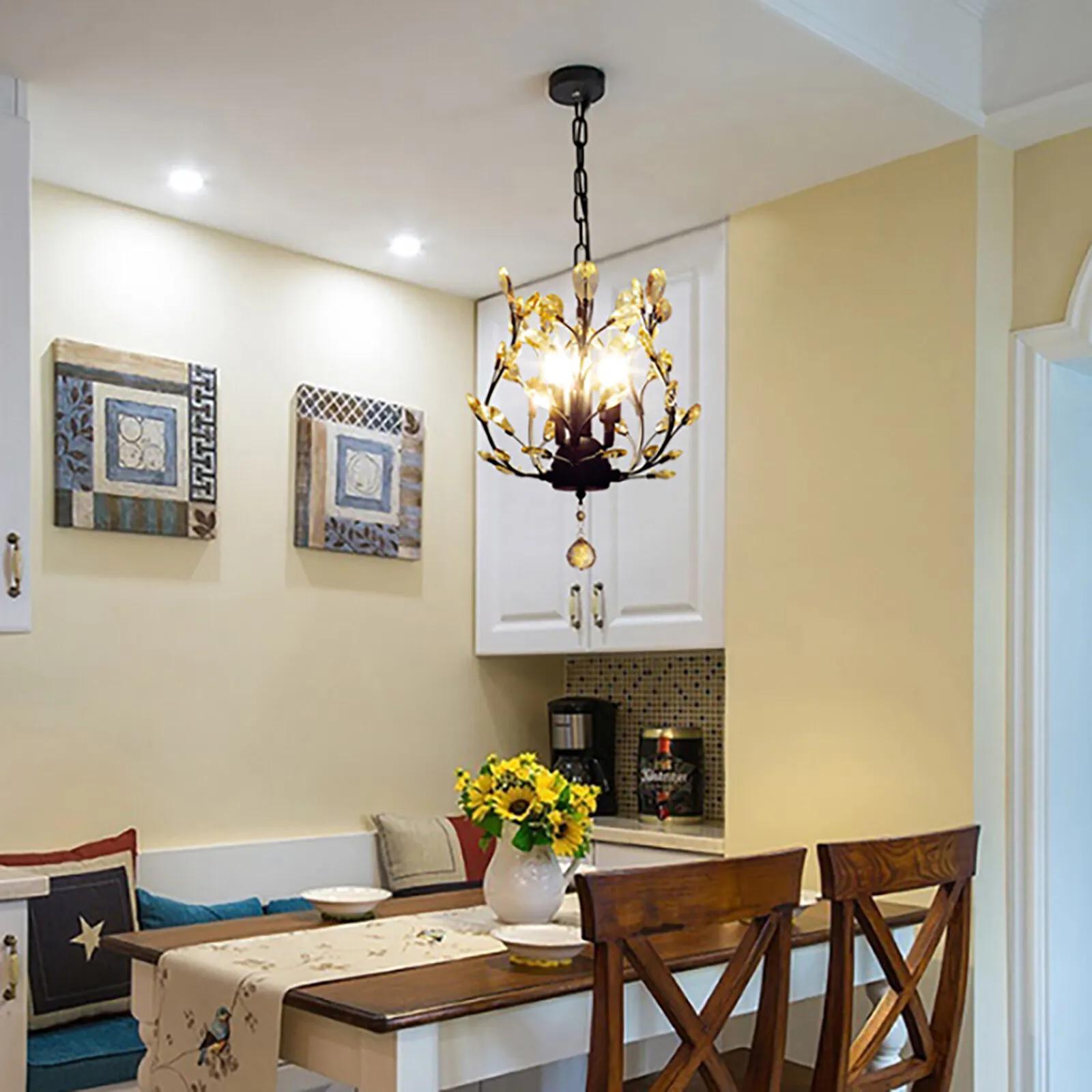 Soft lighting from a modern small chandelier enhances a compact table area with crystal accents