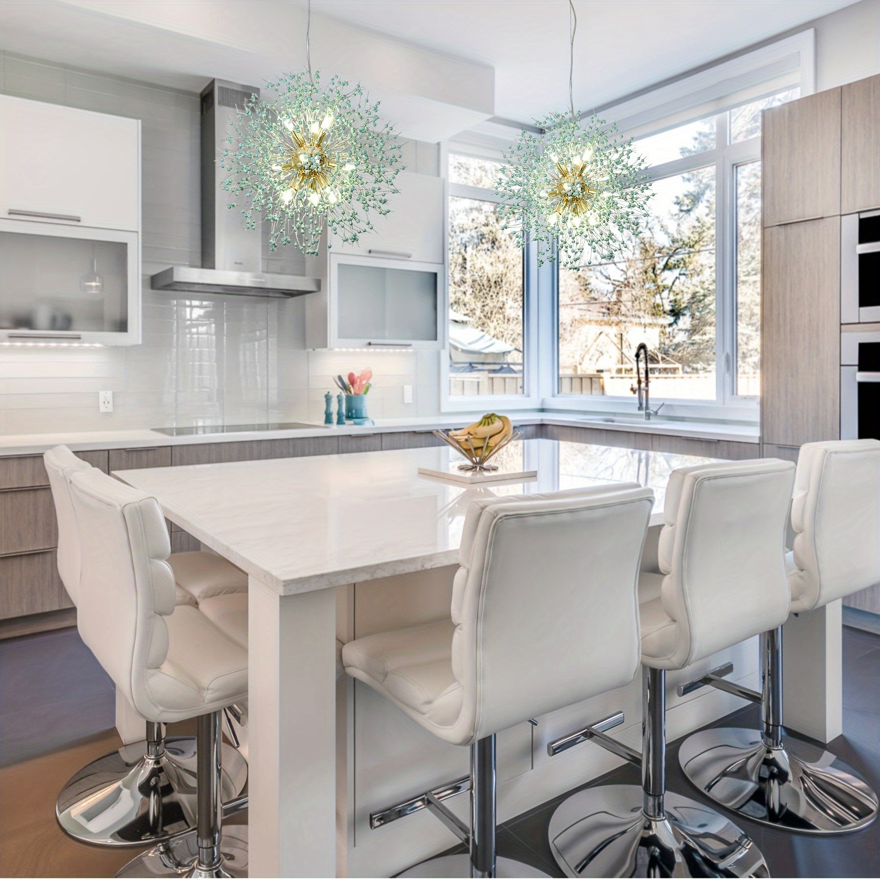 Dandelion-inspired chandeliers with gold accents hanging above a sleek white kitchen island with white bar stools and panoramic windows