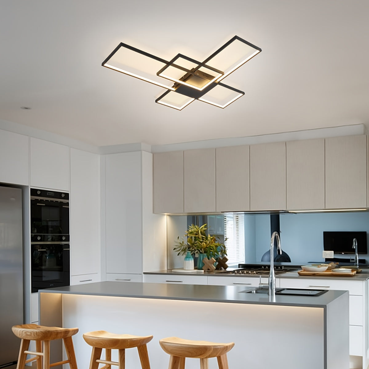 Bright kitchen interior with a mounted geometric LED ceiling light, surrounded by white cabinetry, wood bar stools