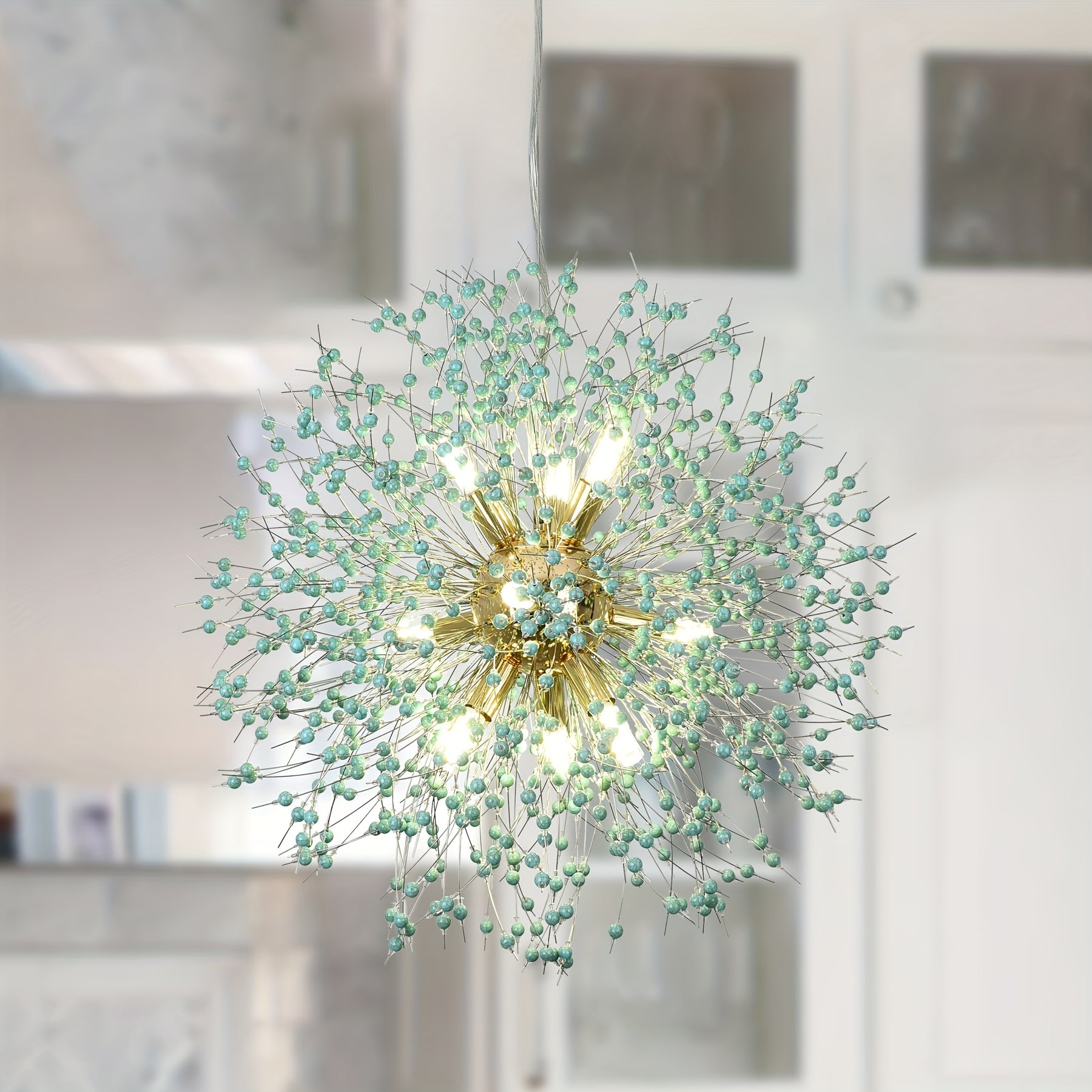 Delicate dandelion-style chandelier with gold center and radiant branches adorned with small green beads