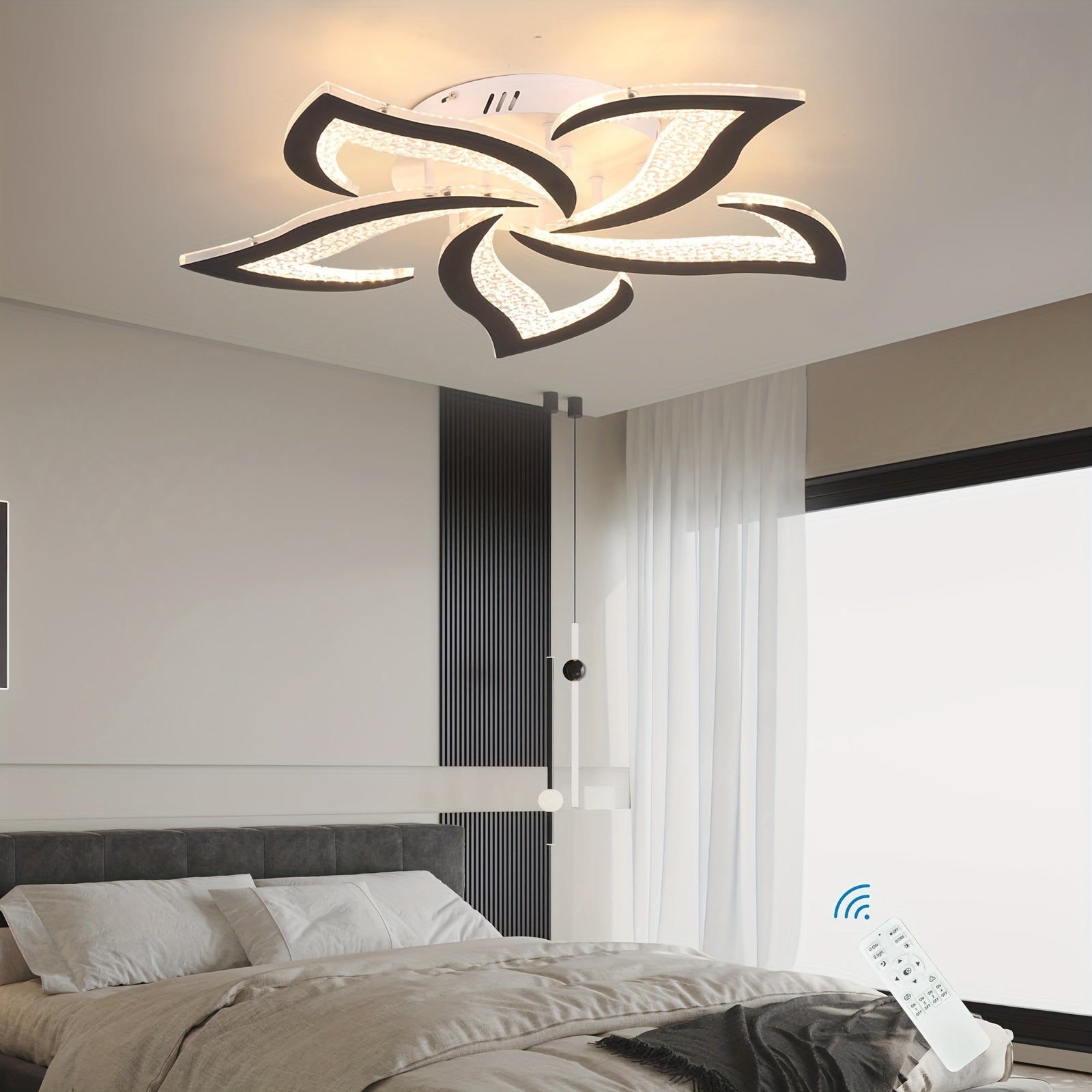Sculptural ceiling fixture with white LED panels and black trim, mounted above a bed and paired with a wireless remote for light control