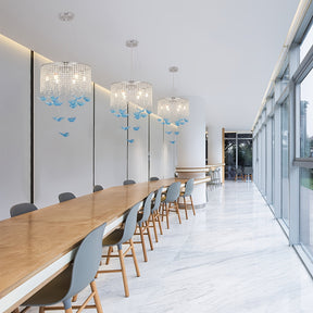 Long seating area with 3 butterfly light fixtures featuring crystal strands and blue hanging butterflies suspended from the ceiling