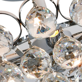 Close-up of crystal bubble light fixture featuring faceted glass spheres and chrome hardware with warm interior glow