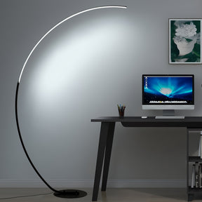 Arc floor lamp casting bright, cool light over a minimalist desk and computer, perfect for enhancing productivity in a home office