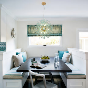 light fixture with gold center and green accents hanging above a cozy built-in dining nook with striped cushions