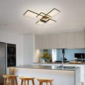 Bright kitchen interior with a mounted geometric LED ceiling light, surrounded by white cabinetry, wood bar stools