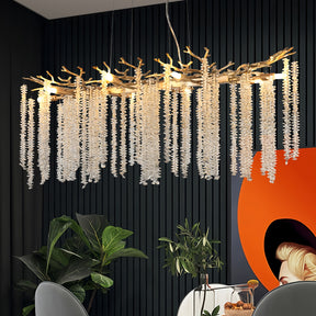 Branch-style crystal chandelier glowing above a modern dining setup, enhancing the space with artistic lighting and elegant detail