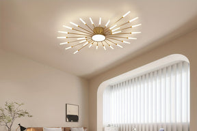 A gold sputnik flush mount ceiling light installed in a contemporary space with neutral walls, arched window, and a cozy seating area