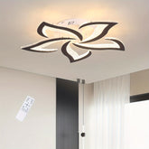 Black-trimmed flower-shaped LED ceiling light illuminating a minimalist space with white curtains and a vertical black wall feature