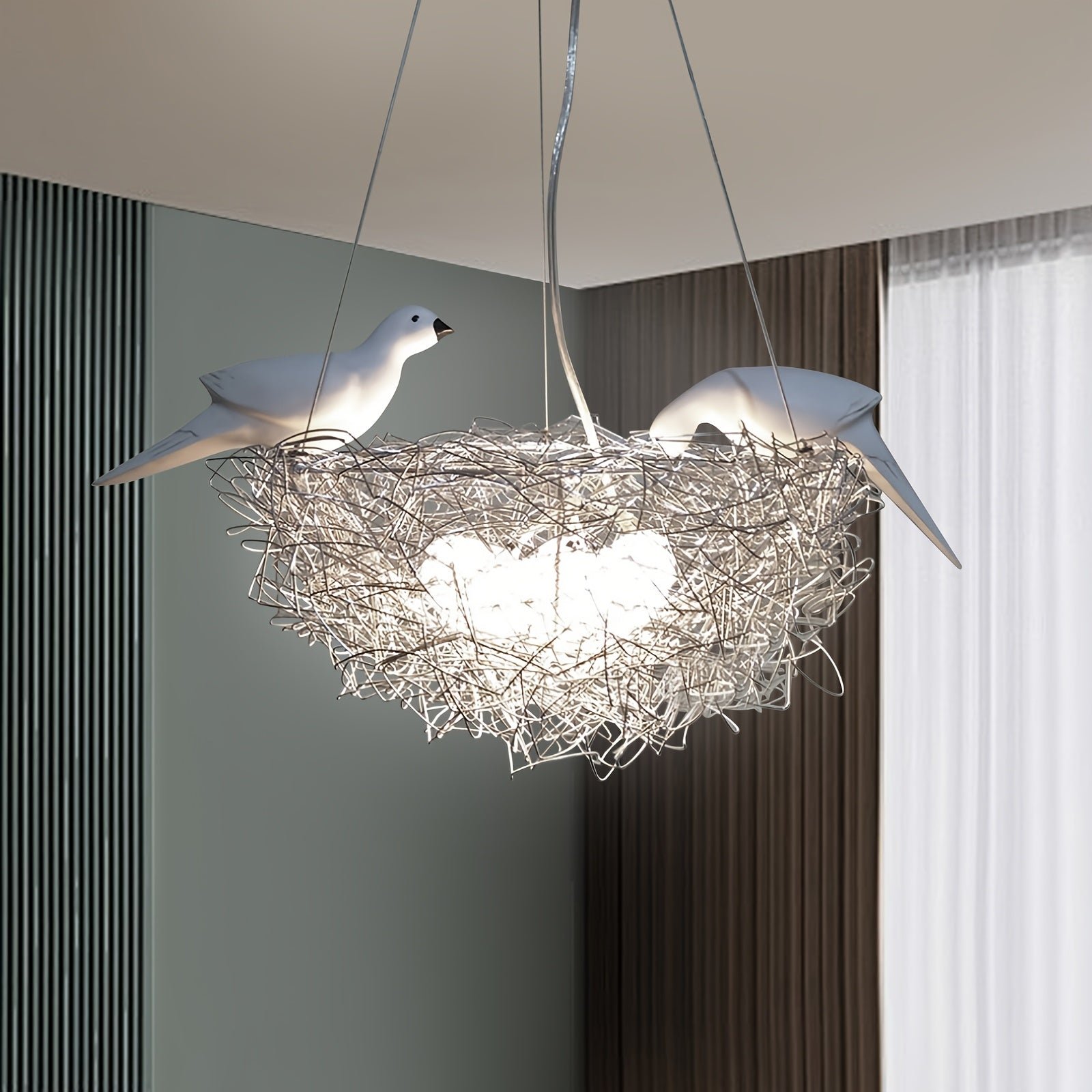 Art-inspired pendant light shaped like a bird nest with two perched birds and woven wire design, creating a soft ambient glow