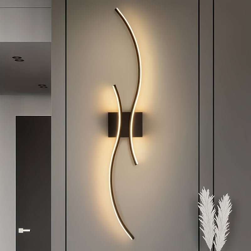 Modern hallway featuring a contemporary LED wall light with dual curved bars mounted on a black base, casting a warm glow on the wall
