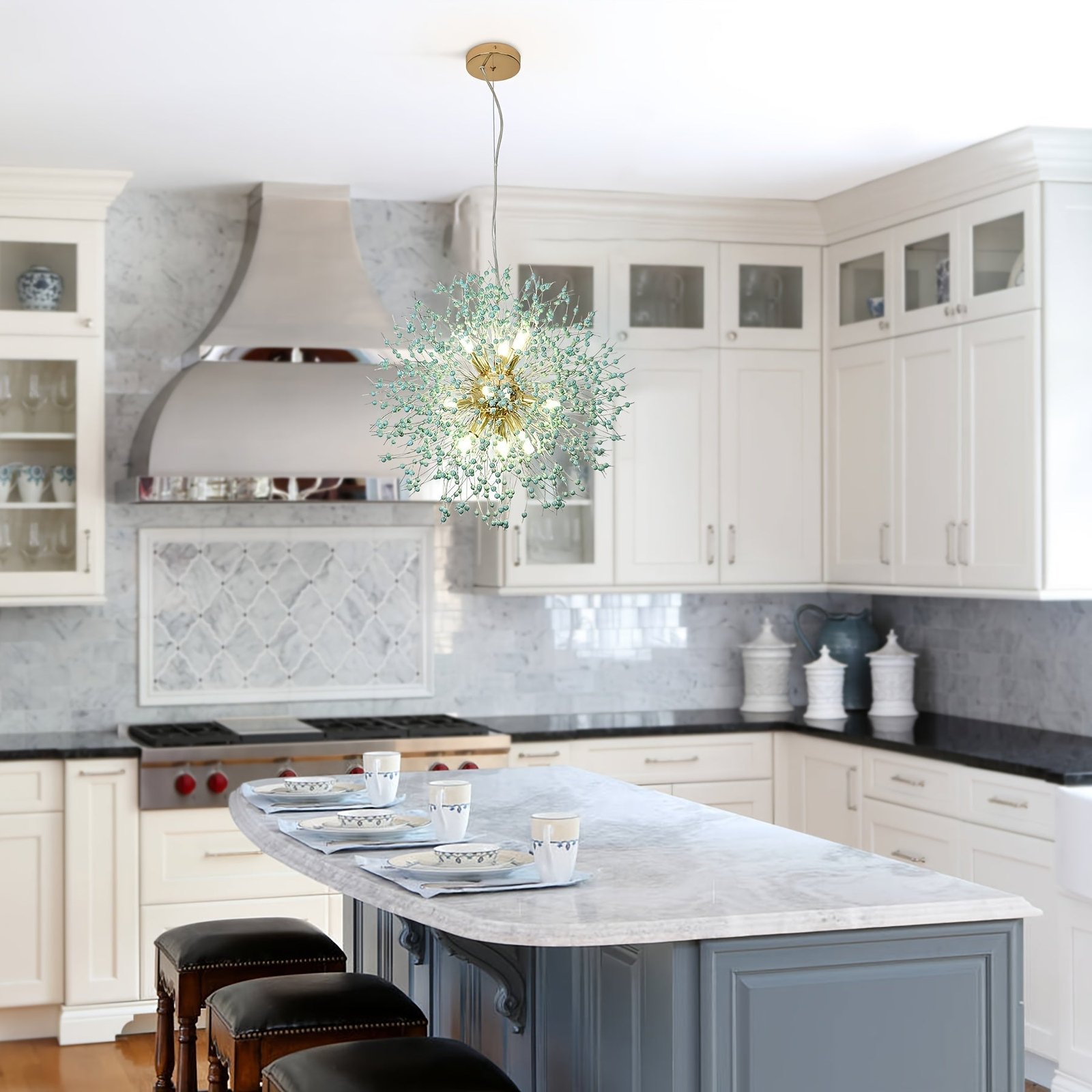 Pendant light with dandelion-style design suspended over a marble island, featuring glowing bulbs and green crystal details