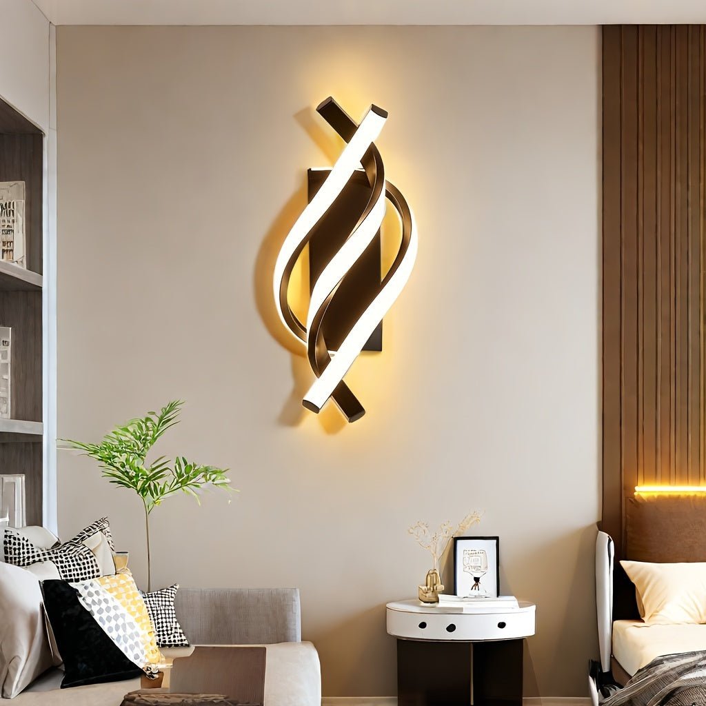 Curved LED wall sconce fixture mounted in a modern living room, casting warm ambient light on a neutral accent wall